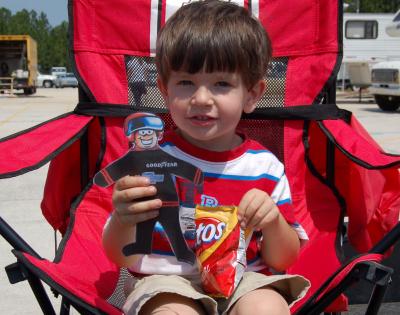 Flat Stanley watches races with boy: Flat Stanley visits with a new friend while watching the races.